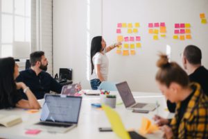 mulher apresentando ideia para equipe praticando comunicação verbal e não verbal